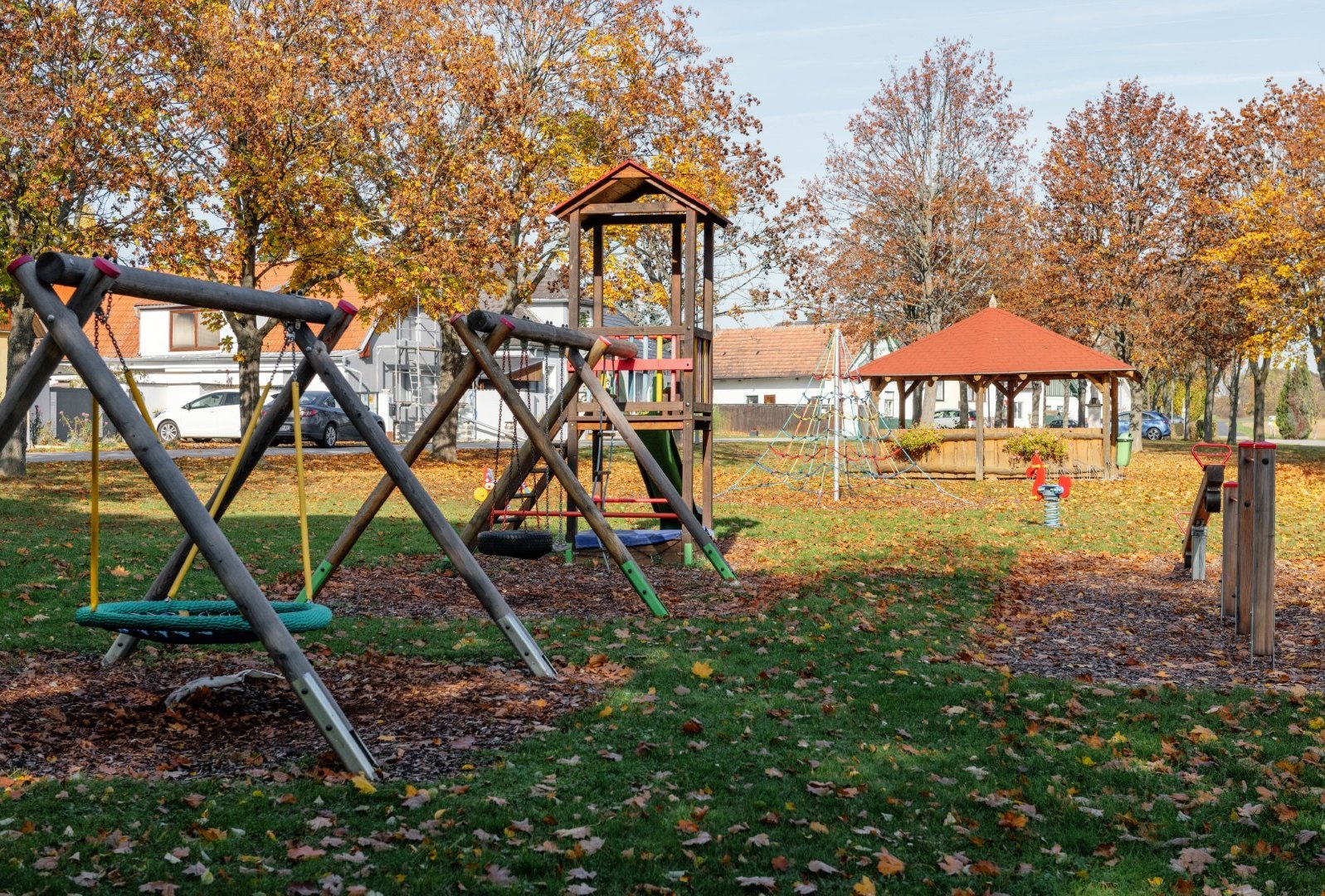 [Translate to Burgenland-Kroatisch:] Schaukeln und Kletterturm am Spielplatz in Kleinwarasdorf